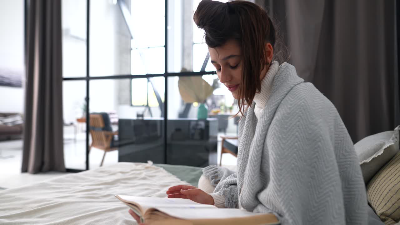 Donna che legge un libro in una camera da letto accogliente