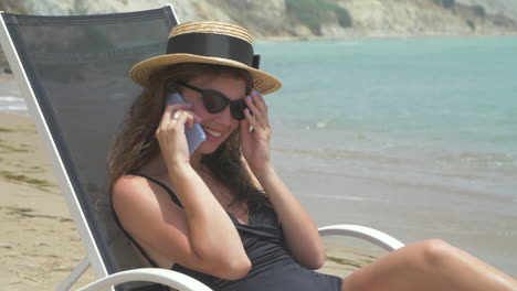 mujer hablando por teléfono en la playa