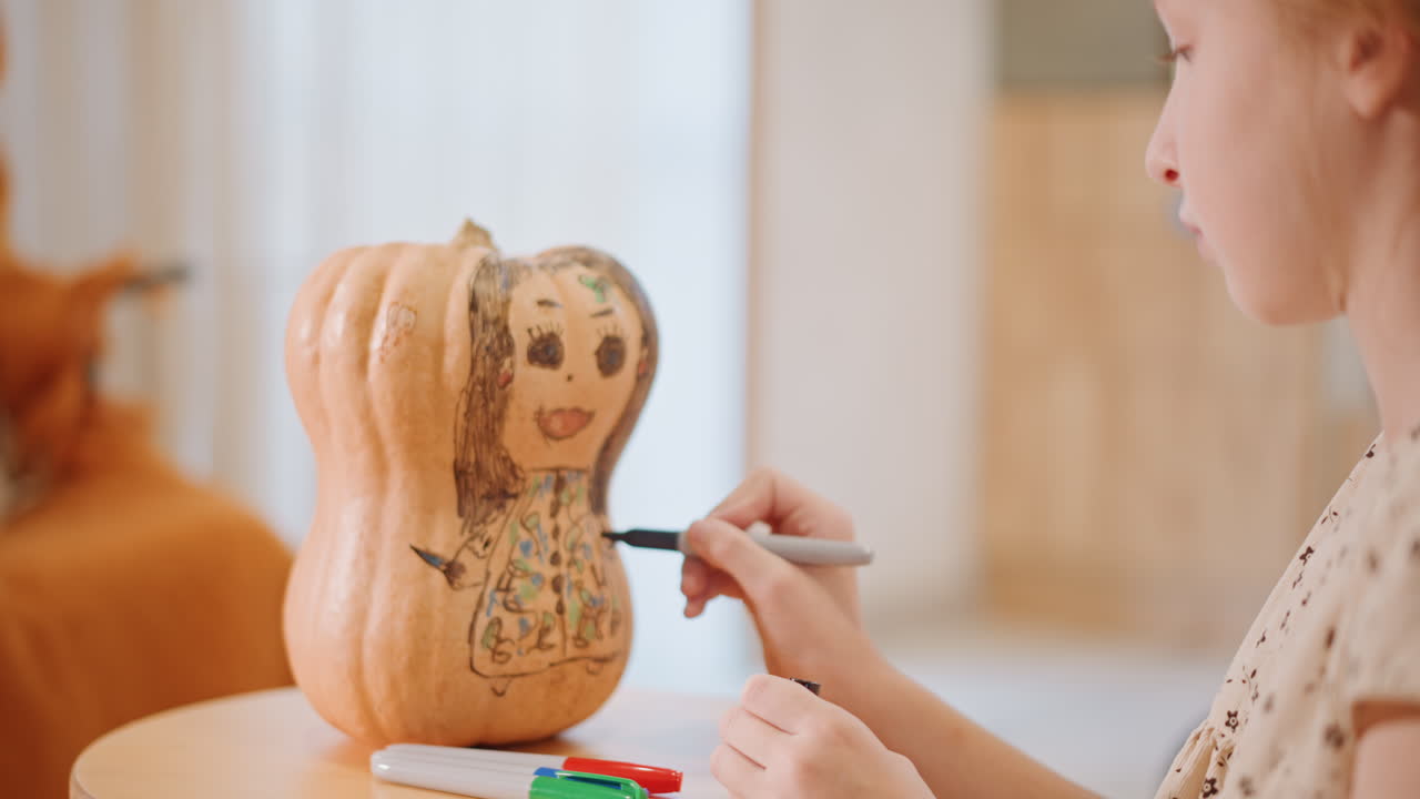 Ragazza bianca che disegna su una faccia di zucca, scena interna accogliente con sgabello di legno, pennarelli e pastelli sul tavolo, espressione concentrata, luce calda e soffusa, decorazioni autunnali, mani che aggiungono un volto sorridente e motivi floreali