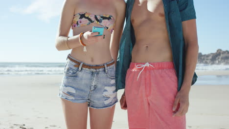 disparo a una pareja caucásica usando un teléfono inteligente en la playa
