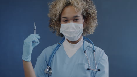 female doctor or nurse with syringe and mask