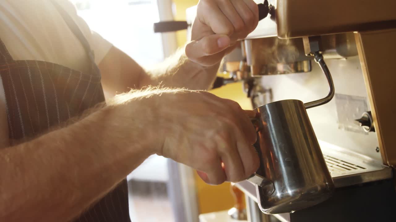 Männlicher Kellner bedient Kaffeemaschine im Café 4k
