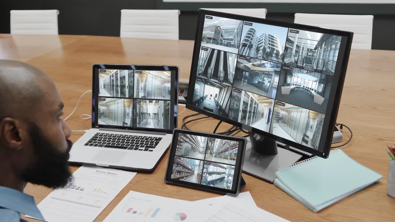 oficial de seguridad afroamericano con negocios cámaras de cctv vistas en tres pantallas, cámara lenta