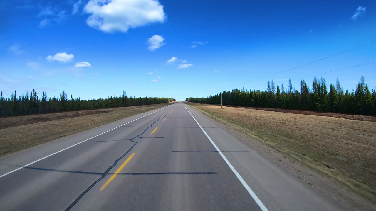 POV through the rear window of the Alaska Highway in the Liard Hot Spring Provincial Park in the Canadian Rockies while in northern British Columbia, Canada on a bright sunny day