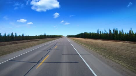 pov through the rear window of the alaska highway in the liard hot spring provincial park in the canadian rockies while in northern british columbia, canada on a bright sunny day