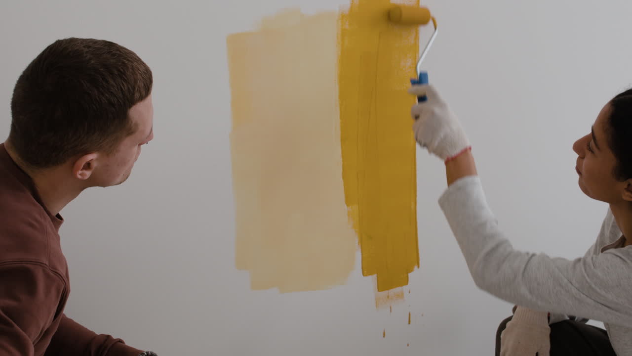 pareja pintando una pared juntos