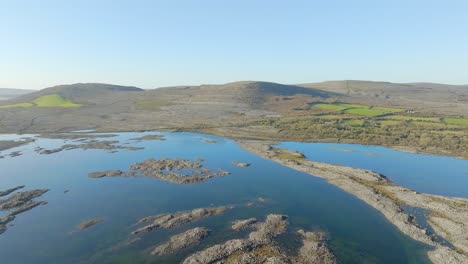 panoramic aerial establishes blue sky reflecting in flood waters on burren ireland with stunning rock formations