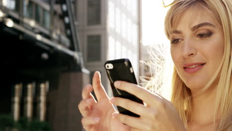 Schöne-Blonde-Frau-Nutzt-Smartphone-Sonneneruptions-Sonnenlicht-Energiekonzept