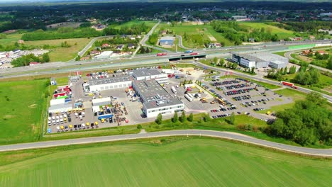 Aerial-top-down-view-of-the-big-logistics-park-with-warehouses,-loading-hub-and-a-lot-of-semi-trucks-with-cargo-trailers-awaiting-for-loading-unloading-goods-on-ramps