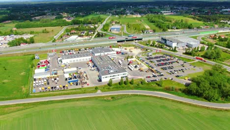 Aerial top down view of the big logistics park with warehouses, loading hub and a lot of semi trucks with cargo trailers awaiting for loading unloading goods on ramps