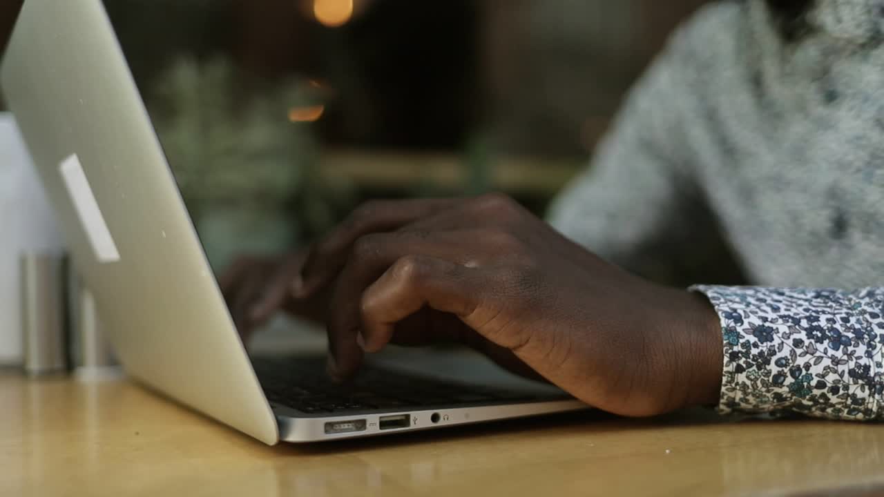 joven trabajando con una computadora portátil en una cafetería