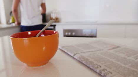 primer plano de un cuenco de desayuno con un periódico en la cocina