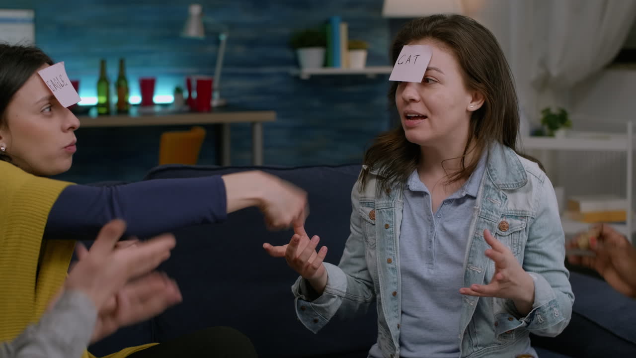 amigos multiétnicos sentados en el sofá tarde en la noche jugando al juego de adivina quién