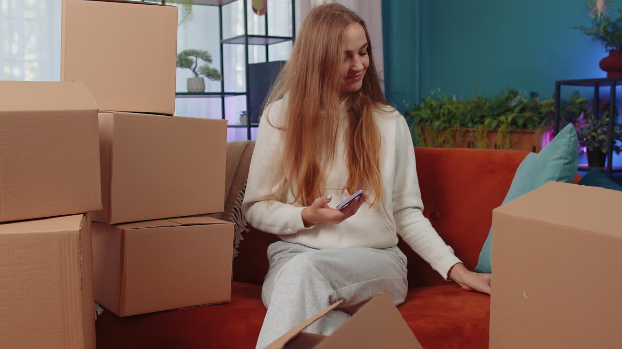 Happy shopaholic woman with shopping gift cardboard box making online payment with credit card, home