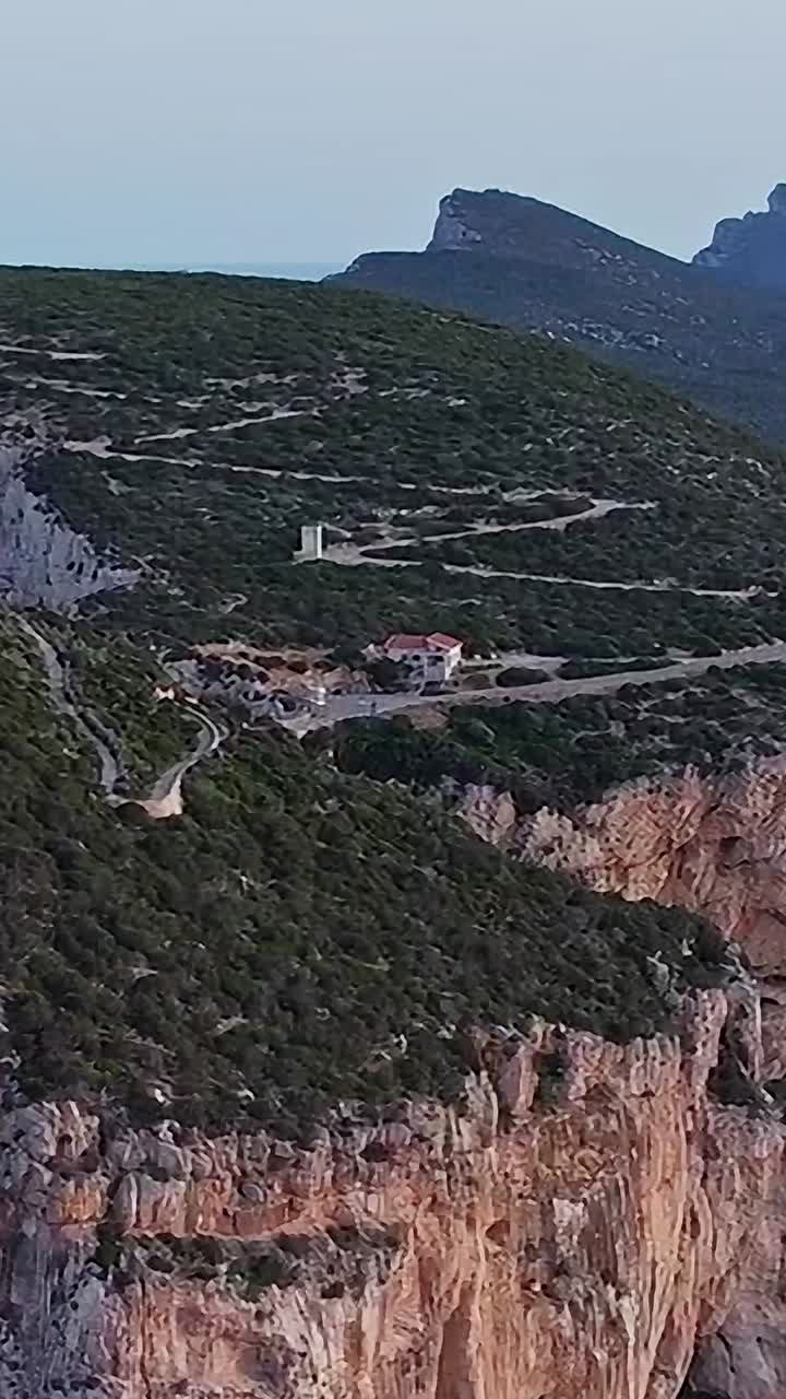 Visita la Sardegna per ammirare un faro su un'alta scogliera rocciosa in riva al mare