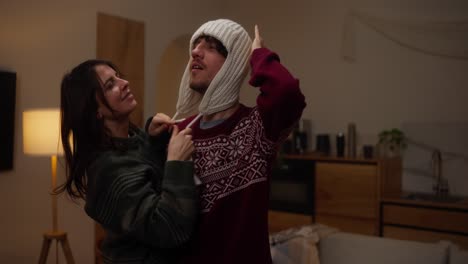 couple wearing winter hats at home