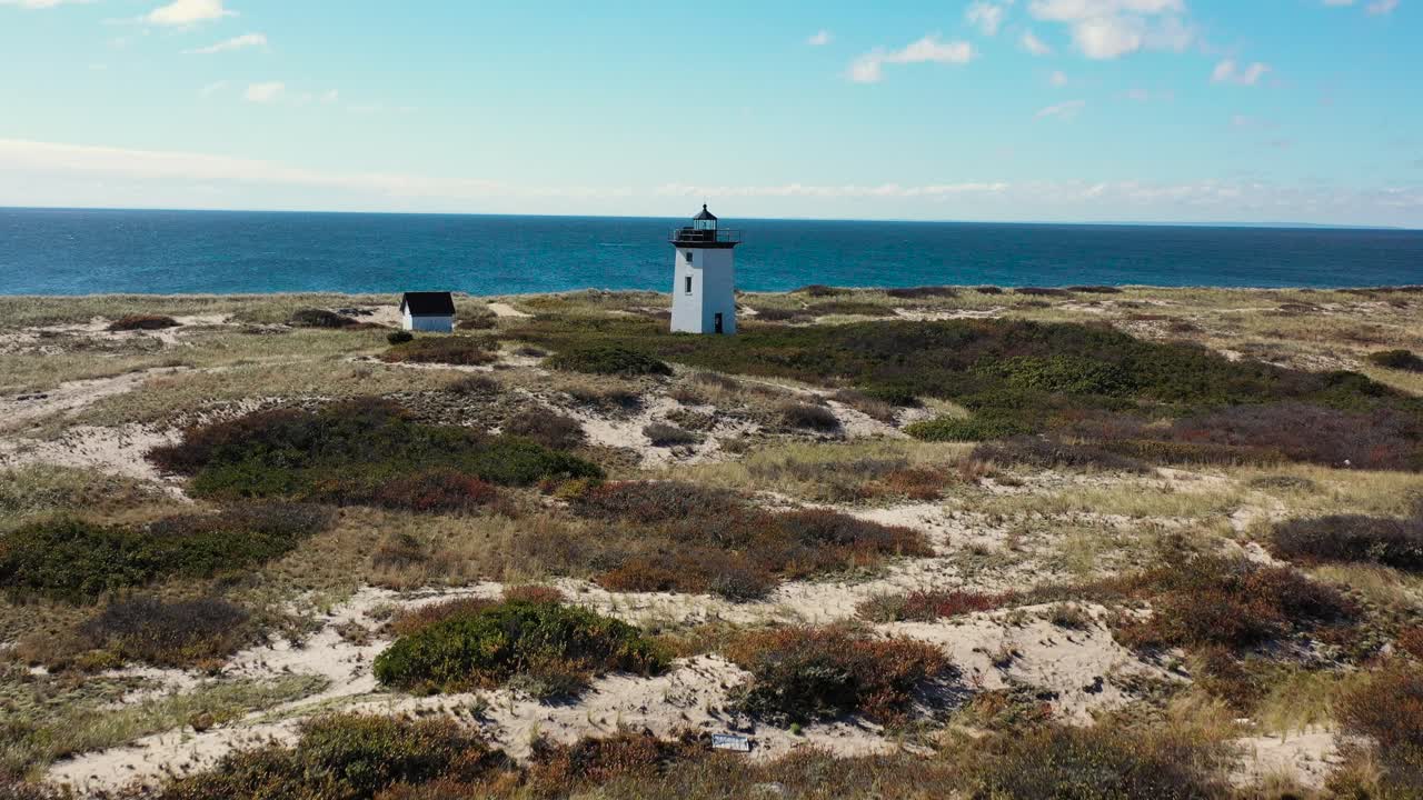 바다를 향해 긴 지점의 북동쪽 끝에 있는 등대 위를 비행하고 있습니다.