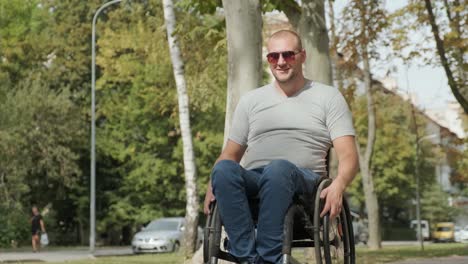 man with disabilities in wheelchair walk at the park alley