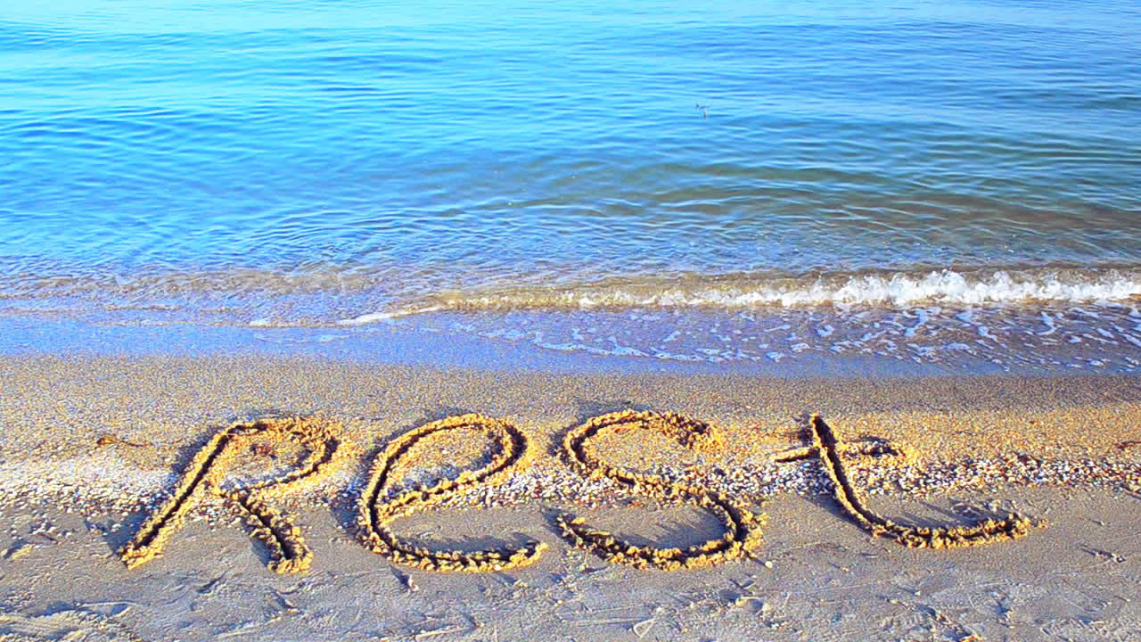 Inscription rest on sand, the beach. Inscription on sand, the beach