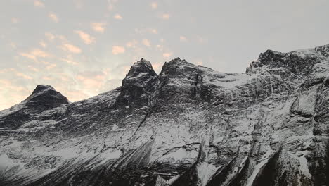 gloomy view of rocky mountain peak and cloudy sky in geiranger norway - tilt up wide shot