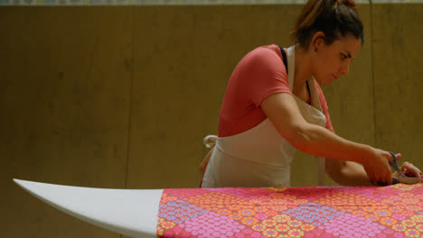 woman cutting fabric for surfboard 4k