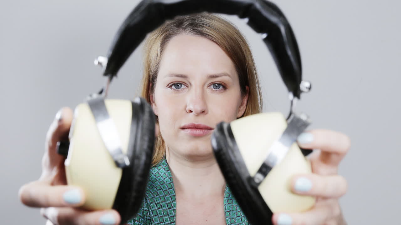 cool female dancer with changing retro headphones to listen to music