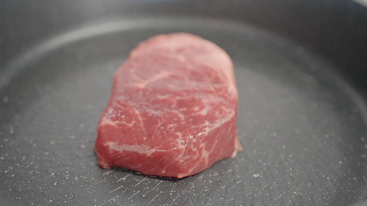 bistec crudo en una sartén