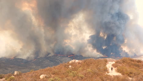 dramatic wildfire landscape, huge smoke plumes in background, moutain hills burning, fairview fire, california