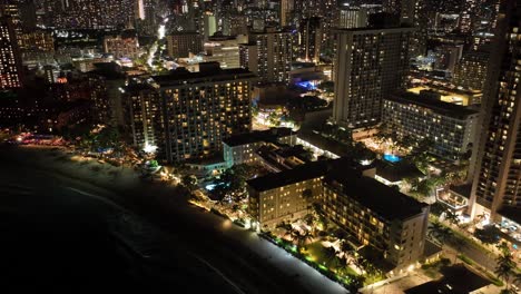 在夜晚的威基基街道的空中无人机时间延迟与酒店和城市灯光在霍诺卢卢夏威夷的交通