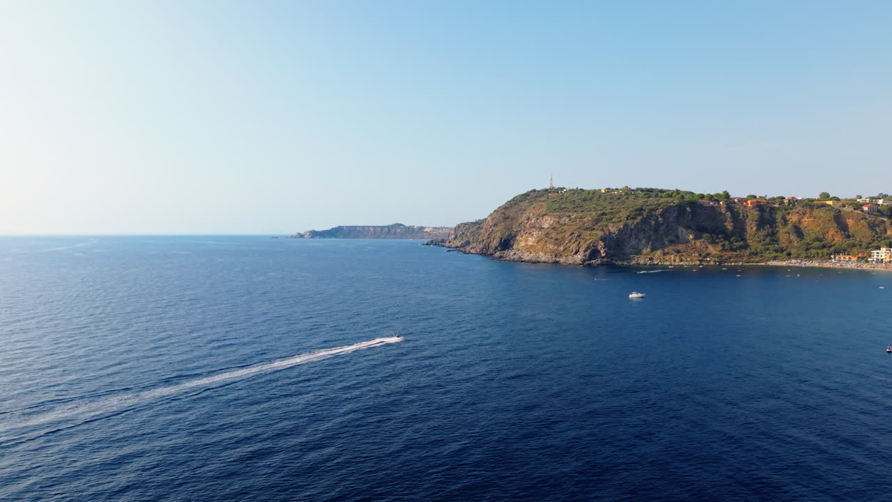 Vista aerea del paesaggio siciliano, spiaggia con moto d'acqua nel mare blu, scogliere italiane, luogo di viaggio naturale