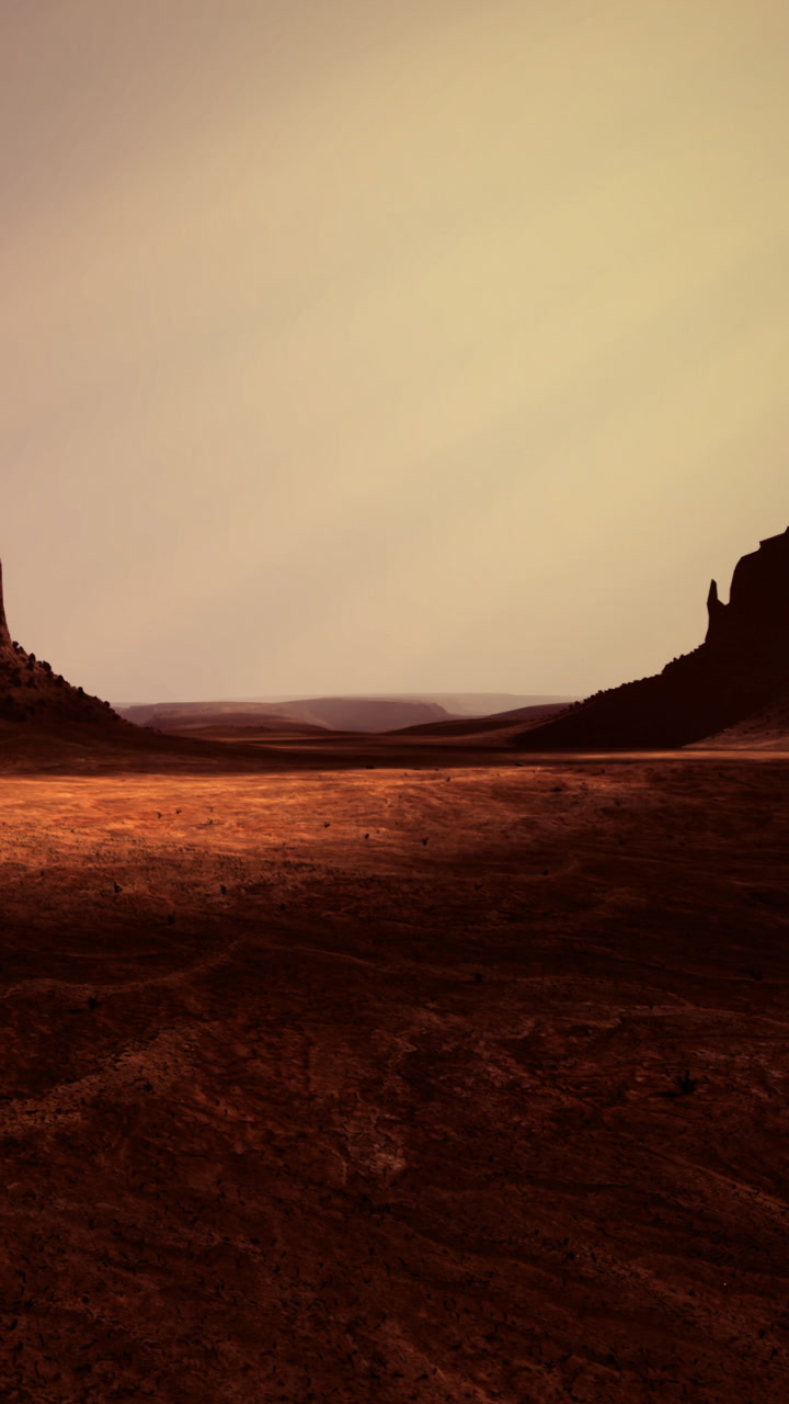 Vast landscape with red soil and dark rock formations under cloudy sky