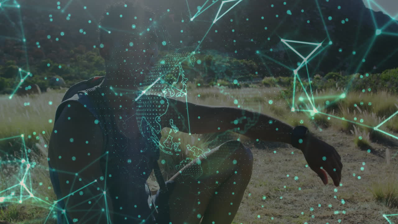 Male athlete kneeling on grassy field, interacting with hologram globe and nodes in tech demo