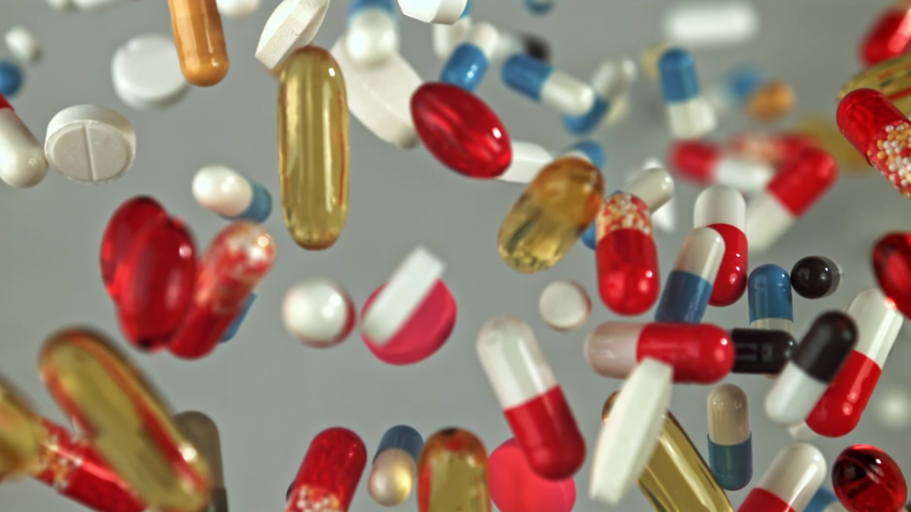 Colorful Pills and Capsules Falling in Slow Motion