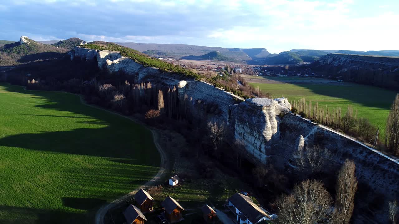 극적인 절벽과 작은 마을이 있는 계곡의 공중 풍경