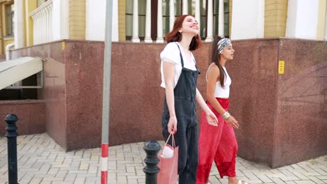 two young women walking in city street