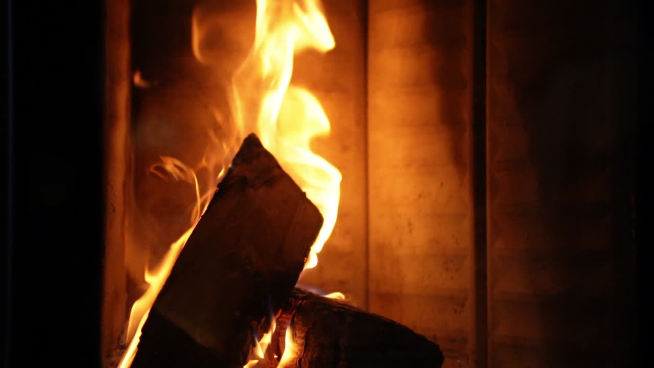 firewood burning in a fireplace on a cozy evening in slowmotion