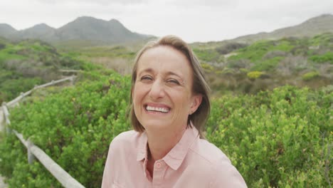 portrait of smiling senior caucasian woman standing on path