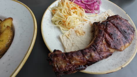 presentación de un plato de pollo a la parrilla con cebollas de queso y patatas en primer plano