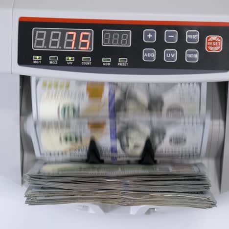 money counting machine with 100 dollar banknotes. us national paper currency. bank automatic equipment for calculation paper currency, finance concept