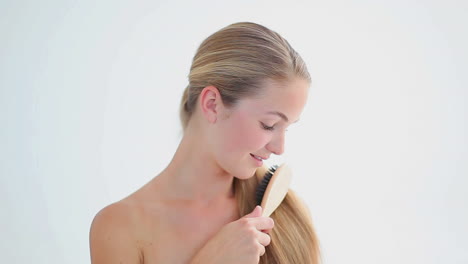 Smiling-blonde-woman-brushing-her-hair