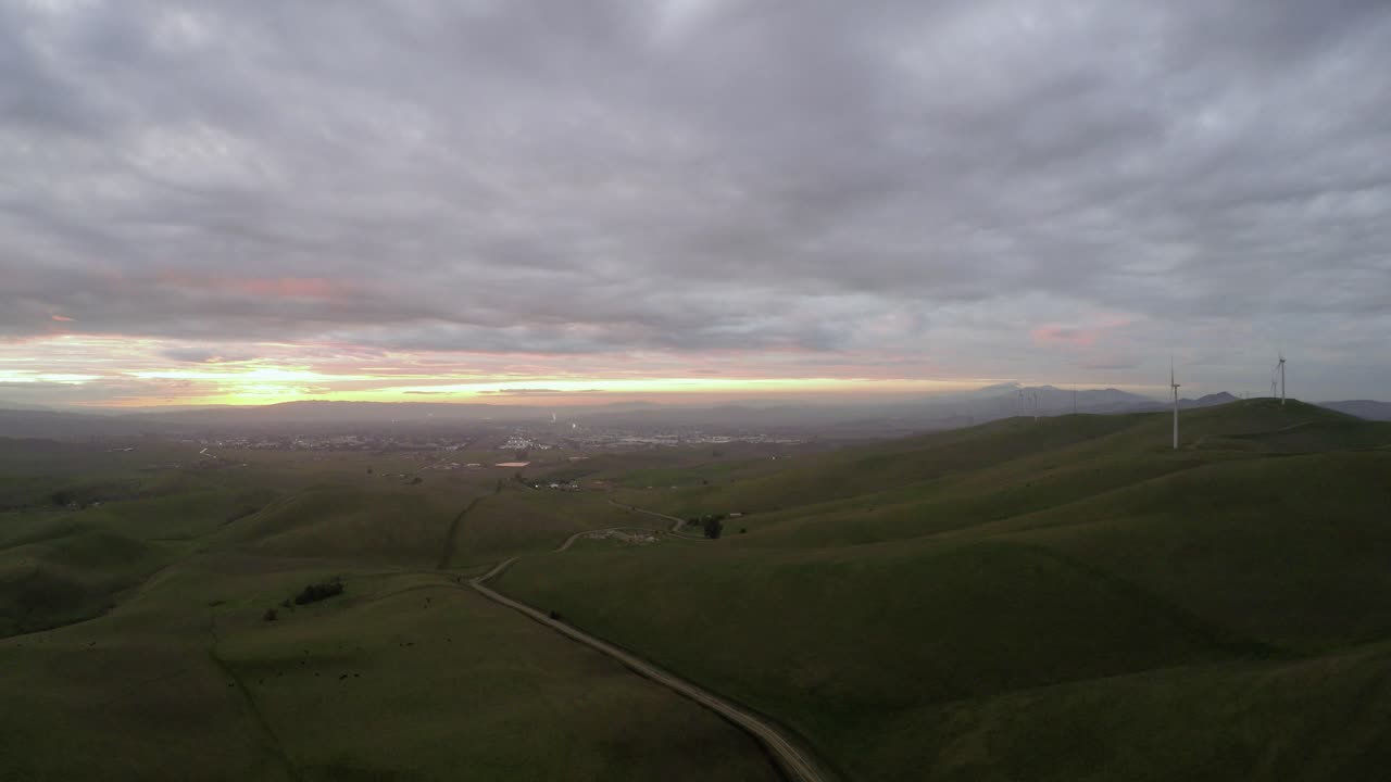 Side Dolly Wide Shot of Wind Turbines at Sunset with Moody Clouds