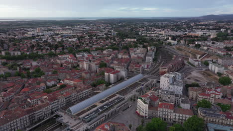 Montpellier-Saint-Roch-train-station-France-aerial-back-traveling-during-sunrise