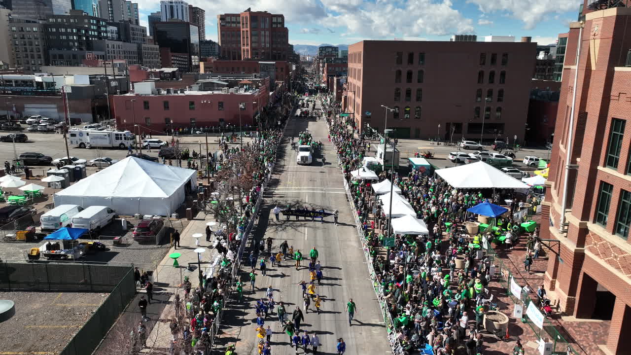 vista aérea de un desfile del día de san patricio mientras la gente vestida de verde marcha por las calles