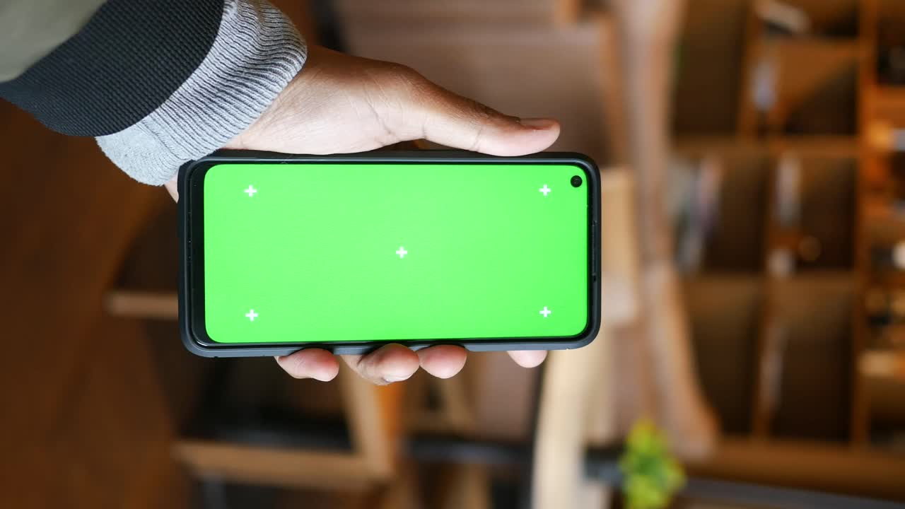 Smartphone with green screen held by hand