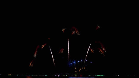 Captura-Más-Cercana-De-Los-Fuegos-Artificiales-Culminantes-En-El-Mar-Mientras-La-Gente-Mira-Desde-La-Playa,-Festival-Internacional-De-Fuegos-Artificiales-De-Pattaya-2023,-Tailandia