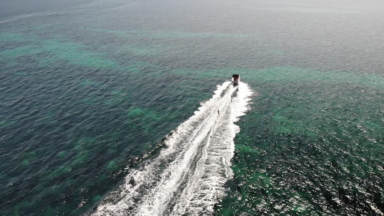 다음 추격 공중: 모터보트 수상 스키어가 맑은 물에서 깨어납니다.