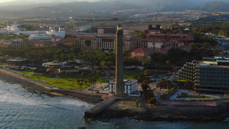 Maravillosa-Vista-Aérea-En-órbita-Cerca-Del-Faro-De-Maspalomas-Durante-La-Puesta-De-Sol-Y-Con-Vistas-A-La-Costa