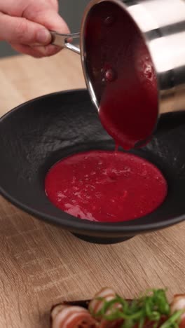 pouring beetroot soup into a bowl