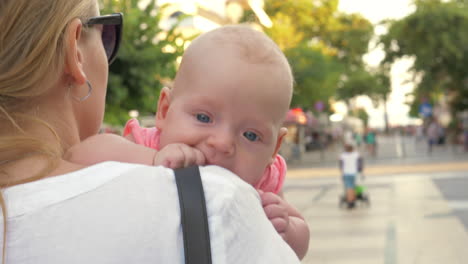 baby having outdoor walk in mothers arms