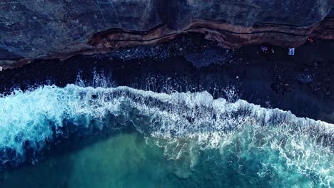 Vista-De-Pájaro-De-Olas-Frías-Que-Se-Desvanecen-Suavemente-En-La-Playa-Rocosa,-Tenerife,-España